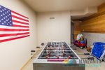 Foosball table, skim boards, beach chairs and beach wagon with toys.